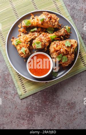 Pollo fritto tailandese in stile Hat Yai con cipolla croccante da vicino su un piatto sul tavolo. Vista dall'alto verticale Foto Stock