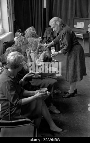 Darby e Joan Club. Una lezione di danza pomeridiana non vedente e ipovedente per anziani al Battersea Institute. Il pianista aiuta con le tazze di tè per i pensionati ciechi del tè. Battersea, Londra, Inghilterra circa 1970. 1970S UK HOMER SYKES Foto Stock