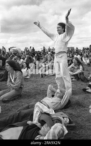 Stonehenge Free Festival al solstizio d'estate, 21 giugno 1976. Per celebrare la musica, una band dal vivo è sul palco - festival pop gratuito - Wiltshire, Inghilterra, Regno Unito anni '1970, HOMER SYKES Foto Stock