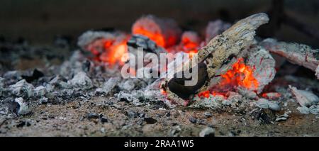 Cenere e fiamme rosse all'interno di legna bruciata, Mahe Seychelles Foto Stock