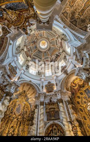 Siviglia, Spagna - 16 giugno 2023: Veduta interna ad ampio angolo della Cupola, delle pale d'altare e del ceilling di stile barocco della Chiesa di San Luis de los Franceses. Foto Stock