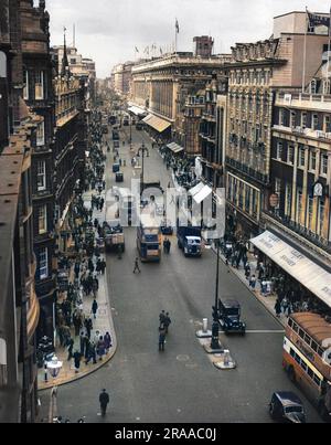 Oxford Street, la principale via dello shopping di Londra - una vista aerea che mostra autobus e acquirenti che affollano il marciapiede. Il tempio del commercio, Selfridges, con bandiere che volano, può essere visto in lontananza. Data: c.1950 Foto Stock