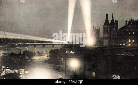 Proiettori che lanciano alberi di luce sullo skyline di Londra nel settembre 1914, alla ricerca di aerei Zeppelin tedeschi. Il Tatler commenta che, "e con le strade oscurate, le case pubbliche chiuse alle undici, i soldati ovunque e i proiettori che lampeggiano in tutte le direzioni, Londra presenta al momento un aspetto che è sufficiente per far esplodere il più antico abitante e per portare in qualche misura davanti a noi la realtà della guerra”. Data: 1914 Foto Stock