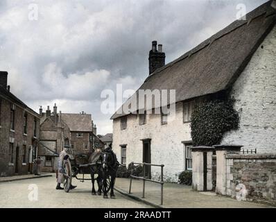 Un cavallo e un carro all'aperto in un grazioso cottage tradizionale con tetto in paglia a Oakham, Rutland, Inghilterra. Data: Anni '1950 Foto Stock