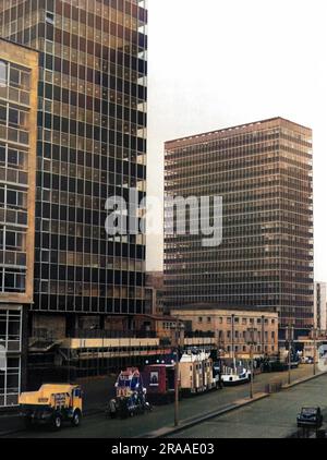 Alti edifici "moderni" per uffici nel London Wall, City of London. I veicoli decorati fanno parte dello spettacolo del Lord Mayor, in attesa di unirsi alla processione. Data: Anni '1960 Foto Stock