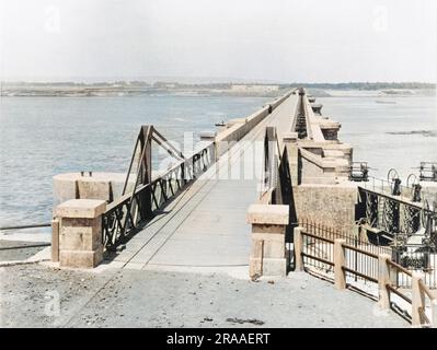 Carreggiata e ponte sospeso sopra la chiusa sulla diga di Assiut o Asyut sul Nilo in Egitto, a circa 350 km a valle della diga di Assuan. Data: 1902 Foto Stock