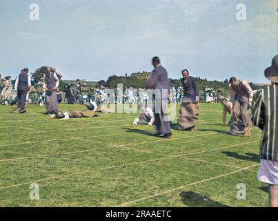 I padri sportivi prendono parte a una gara di sacchi ideata appositamente per loro in una giornata di sport scolastici a Seaford, Sussex. Molti di loro sono caduti o sono in procinto di farlo. Data: 1934 Foto Stock