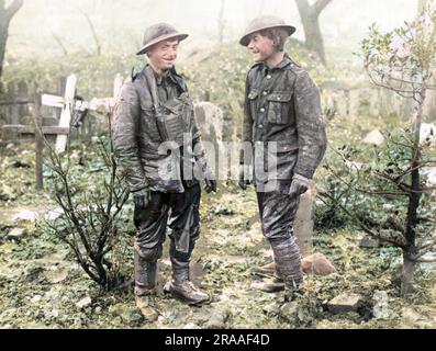 Due soldati britannici sul fronte occidentale durante la prima guerra mondiale. Le loro uniformi sono macchiate di fango, e sono in piedi in un cimitero. Data: 1914-1918 Foto Stock