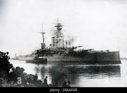 HMS Royal Sovereign, nave da battaglia della classe British Revenge, varata nel 1915, servì nella prima guerra mondiale e parte della seconda guerra mondiale. Visto qui con un rimorchiatore accanto, e gente che guarda dalla terra. Data: XX secolo Foto Stock