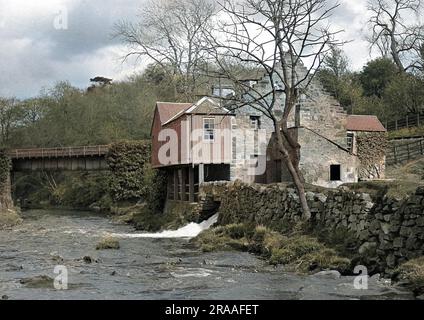 Vista di un mulino sul lato di un fiume. Foto Stock