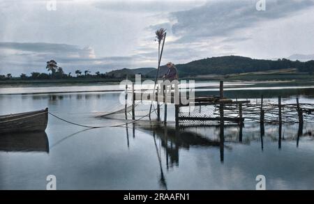 Uomo su un molo con reti da pesca, River Dee, Kirckcudbright, Scozia. Data: 1928 Foto Stock