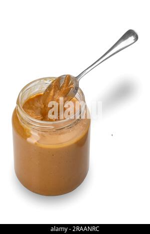 Burro di arachidi in un vaso di vetro aperto con vista dall'alto con cucchiaino, isolato su bianco con percorso di ritaglio incluso Foto Stock