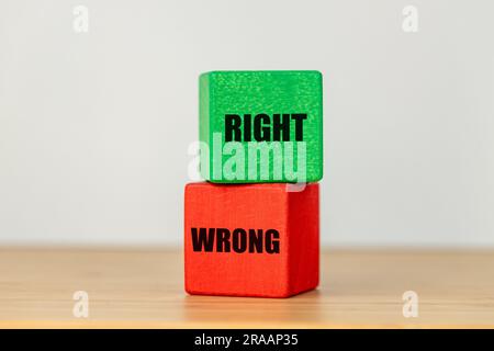 Due blocchi di legno rosso con la parola sbagliata e verde con il testo giusto il concetto di prendere le decisioni giuste Foto Stock