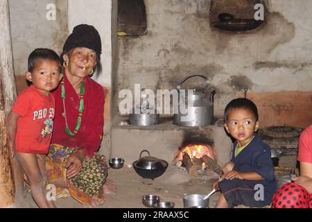 Una famiglia Nepalese Limbu cena nella tradizionale cucina nepalese Foto Stock