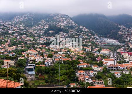 Case costruite sul lato delle montagne vulcaniche, Funchal, Madeira Foto Stock