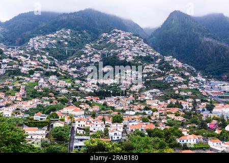 Case costruite sul lato delle montagne vulcaniche, Funchal, Madeira Foto Stock