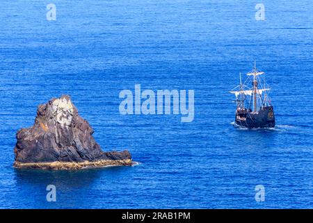 Una nave pirata turistica naviga davanti a una piccola isola con molti turisti a bordo. Foto Stock