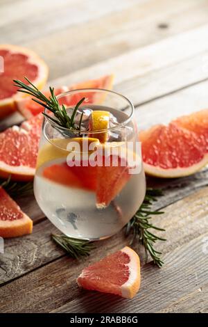 Un bicchiere di gin tonic con fette di pompelmo, verde rosmarino, cubetti  di ghiaccio e la palla di Natale Foto stock - Alamy