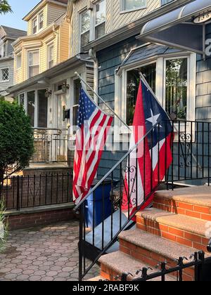 Bandiere americane e portoricane esposte a casa in una strada residenziale nel quartiere Kensington di Brooklyn, New York. Foto Stock