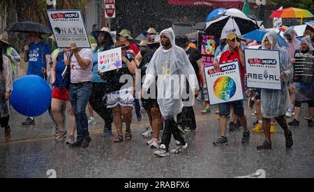 Piedi Lauderdale, Florida, USA. 2 luglio 2023. I manifestanti marciano per le strade del centro di Fort Lauderdale, Florida, in un diluvio durante la marcia nazionale We the People. Nonostante il tempo inclemente, diverse migliaia di persone si sono rivelate per l'evento. La marcia fu messa in scena nel centro di Fort Lauderdale, in Florida, il 2 giugno 2023. L'evento si è concentrato sull'erosione della democrazia, sul controllo delle armi, e soprattutto in Florida, sui recenti attacchi alle libertà delle persone gay e transgender. La protesta è stata organizzata dalla AIDS Healthcare Foundation, insieme a oltre 50 organizzazioni partner e coinci Foto Stock