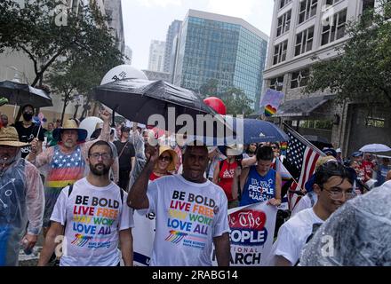 Piedi Lauderdale, Florida, USA. 2 luglio 2023. I manifestanti portano ombrelli e indossano mantelle antipioggia usa e getta mentre marciano per le strade del centro di Fort Lauderdale, Florida . Nonostante il tempo inclemente, diverse migliaia di persone si sono rivelate per l'evento. Il We the People National March è stato messo in scena nel centro di Fort Lauderdale, Florida, il 2 giugno 2023. L'evento si è concentrato sull'erosione della democrazia, sul controllo delle armi, e soprattutto in Florida, sui recenti attacchi alle libertà delle persone gay e transgender. La protesta è stata organizzata dalla AIDS Healthcare Foundation, insieme a oltre 50 membri Foto Stock