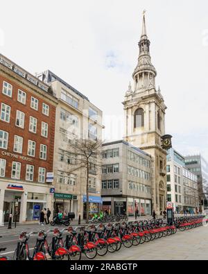 Londra, Regno Unito - 16 marzo 2023; il campanile della chiesa di St Mary le Bow si innalza sopra la fila di biciclette Santander a Londra Foto Stock