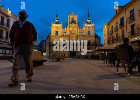 I visitatori si mescolano con la gente del posto in Plaza España mentre il sole tramonta ad Astorga, in Spagna. La vivace città cade lungo il percorso Camino Frances del cammino di Foto Stock