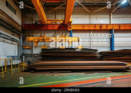 Carroponte con pinze a fascio elettromagnetico che caricano lamiere di acciaio Foto Stock