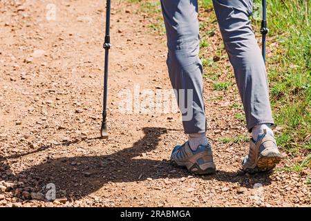 Primo piano di un'escursione a piedi femminili sul sentiero con bastoncini da trekking sul sentiero Foto Stock