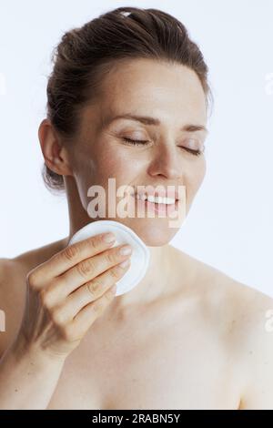 donna moderna e sorridente di mezza età con imbottitura in cotone su sfondo bianco. Foto Stock