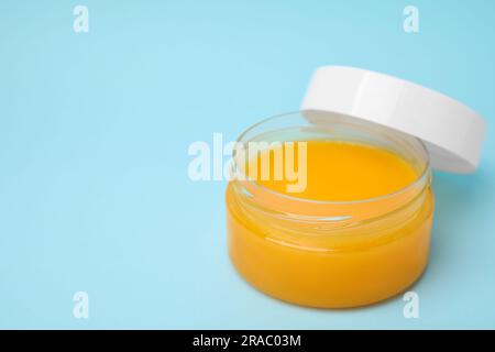 Aprire il contenitore di petrolatum su sfondo azzurro. Spazio per il testo Foto Stock