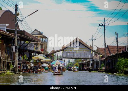 Bangkok, Thailandia. 28 giugno 2023. I turisti a bordo di barche a remi a coda lunga e a motore entrano all'ingresso del mercato galleggiante di Damnoen Saduak. Credito: SOPA Images Limited/Alamy Live News Foto Stock