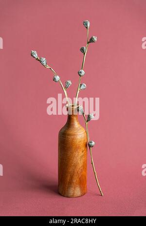 Fiori secchi in vaso di legno. Natura morta minimalista. Foto Stock