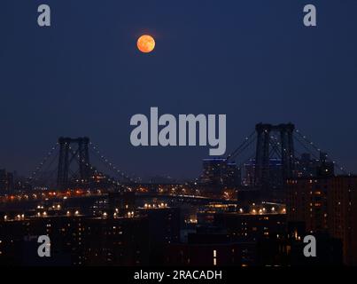 New York, Stati Uniti. 2 luglio 2023. Un Buck Supermoon quasi pieno sorge dietro il Williamsburg Bridge e il quartiere di Brooklyn domenica 2 luglio 2023 a New York City. La superluna di domani segnerà il primo di quattro superlune quest'anno. Foto di John Angelillo/UPI Credit: UPI/Alamy Live News Foto Stock