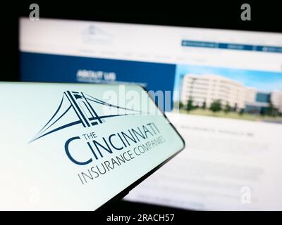 Cellulare con logo della società americana Cincinnati Financial Corporation sullo schermo davanti al sito Web. Mettere a fuoco il display centrale sinistro del telefono. Foto Stock