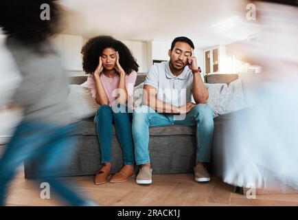 I bambini che corrono con i genitori stressati sul divano per rilassarsi nel soggiorno di casa. Bambini sconvolti, bruciati ed eccitati che giocano con la sfocatura Foto Stock