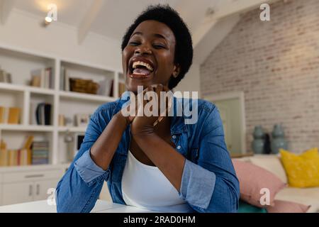 Ritratto di una donna afroamericana adulta con i capelli corti che ride allegramente a casa Foto Stock