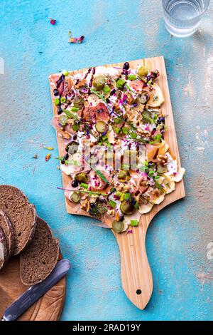 Tagliere di burro con finocchio, cetriolo, prosciutto di Parma, noci, formaggio spalmabile e pane di segale Foto Stock