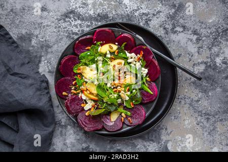 Foglie di insalata con barbabietole, mela, feta e pinoli arrostiti Foto Stock