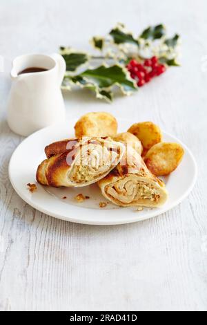 Involtini di pudding dello Yorkshire con cavoletti di Bruxelles, purè di patate e tacchino, serviti con patate arrosto e sugo di carne Foto Stock