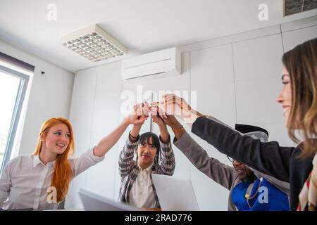 I colleghi uniscono le mani in alto durante una riunione d'affari, concetto di partnership Foto Stock