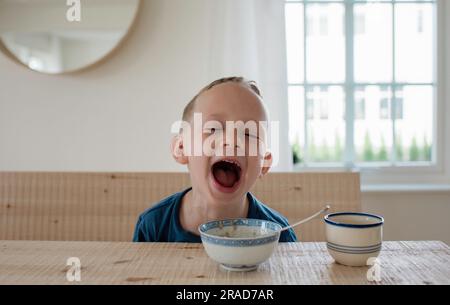 ritratto di un giovane biondo che ride all'ora della colazione Foto Stock