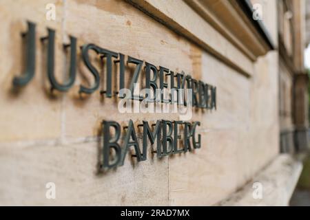 Bamberga, Germania. 3 luglio 2023. "Justizbehörden Bamberg" è scritto sulla facciata esterna del tribunale. Un'udienza di appello di una donna che fa causa al produttore di vaccini AstraZeneca per danni inizia presso il Tribunale regionale superiore di Bamberga (OLG). La donna aveva citato in giudizio la società per danni a seguito di gravi reclami di salute che attribuiva alla vaccinazione con il vaccino Covid-19 del produttore britannico-svedese. La causa è stata respinta perché il Consiglio non ha potuto trovare né un difetto di prodotto né un difetto informativo relativo al vaccino. Credito: Daniel Karmann/dpa/Alamy Live News Foto Stock