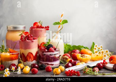 Idee pulite per mangiare a colazione o a uno spuntino. Assortimento di frullati di frutti di bosco, succhi di frutta e budino di semi di chia. Concetto di alimentazione sana. Foto Stock