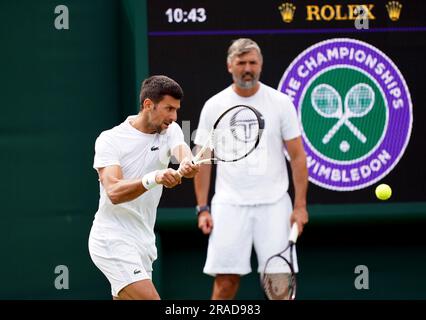 Novak Djokovic è visto dall'allenatore Goran Ivanisevic mentre pratica sui campi esterni il primo giorno dei Campionati di Wimbledon 2023 all'All England Lawn Tennis and Croquet Club di Wimbledon. Data immagine: Lunedì 3 luglio 2023. Foto Stock