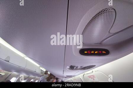 Non fumatori e segnaletica da cintura nel soffitto della cabina dell'aeromobile. Corridoio aereo di linea passeggeri Foto Stock