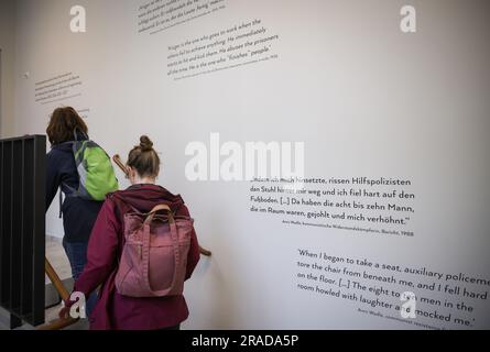 Amburgo, Germania. 3 luglio 2023. Due visitatori camminano su una scala con testi murali nello Stadthaus del sito storico. Lo Stadthaus History Site è stato trasferito alla Hamburg Memorials and Learning Sites Foundation nell'autunno del 2022. Dopo lunghi lavori di ristrutturazione, il sito storico Stadthaus nel centro di Amburgo riaprirà lunedì. Credito: Christian Charisius/dpa/Alamy Live News Foto Stock