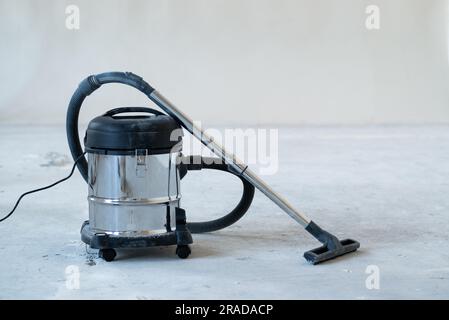 aspirapolvere industriale presso il cantiere edile di una nuova casa, foto striscioni larghe, spazio per testo. Servizio di pulizia concettuale e lavoro di pulizia. Foto Stock