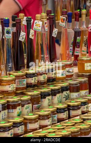 bottiglie di olio d'oliva e varietà di marmellate e conserve in mostra al mercato alimentare di traù vicino a spalato in croazia, esposizione di sottaceti e marmellate fatti in casa Foto Stock