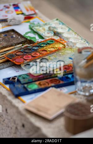scatola o tavolozza di artisti acquerelli con pennelli e tubi di vernice, paintbox artisti, colori diversi in una scatola, scatola materiali artisti. Foto Stock